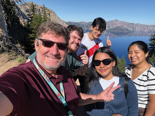 Dr. Fred Griffiths, KCC Coordinator of Global Languages and Learning, left, Shaun Carter, KCC grants post-award coordinator, and the three students enjoy Crater Lake National Park.